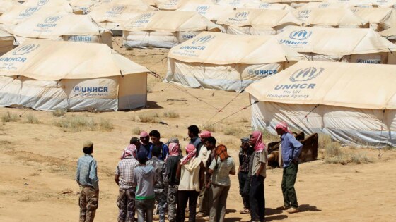 Jordanian workers take a UNHCR official on a walk around tents at the Zaatri refugee camp for Syrian refugees in Mafraq
